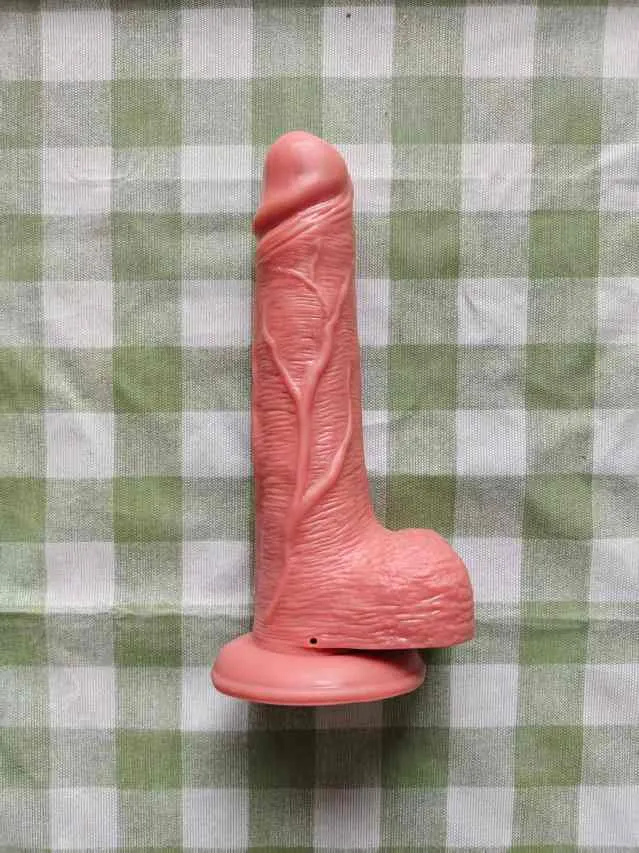 KY31 realistic silicone suction dildo photographed upright on a checked fabric background